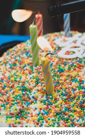 Birthday Candle Close Up On A Cake With Flame Lighting The Candle And Sprinkles On The Cake (portrait) Selective Focus