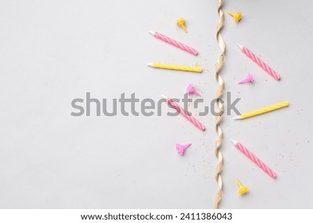 Birthday candles and ribbon on grey background
