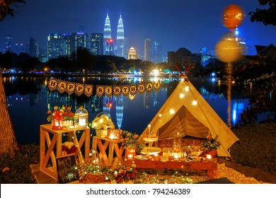 Birthday celebration setup. Isolated nobody outdoor blue hour Birthday Party arrangement tent, tables, cakes, candles, flower bouquets, led lights, gifts and wishes signage at Lake Titiwangsa. 