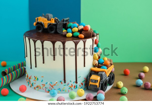 Birthday colorful\
cake for little boy with toy cars and colorful candies decorations.\
Holiday, celebration, stylish concept. Construction and\
transportation theme boys\
party.