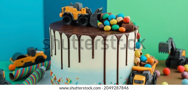 Birthday
colorful cake for little boy with toy cars and colorful candies
decorations. Holiday, celebration, stylish concept. Construction
and transportation theme boys party.
Banner.