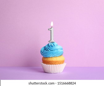 Birthday cupcake with number one candle on violet background