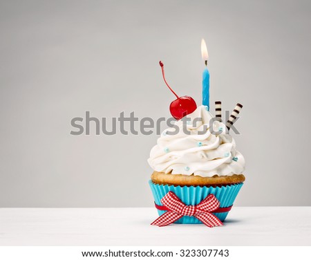 Birthday Cupcake with vanilla buttercream icing, candle and a cherry on top.