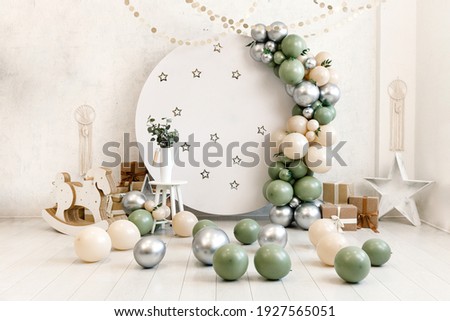 Birthday decorations - gifts, toys, balloons, garland and number for little baby party event on a white wall background.