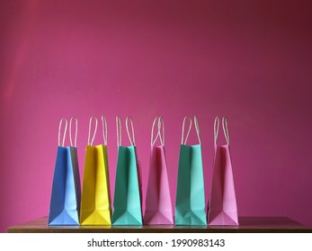 Birthday Gift Bags In A Row On Pink Background Wide Shot