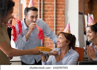 Birthday Girl Mature Female Sitting On Chair Surrounded By Cheerful Friendly Multiracial Colleagues Wearing Hats Use Party Blower Giving Holiday Cake Congratulating Happy Birthday Best Wishes Concept