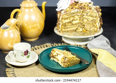 Birthday Layer Cake  With Chocolate Pieces And Hazelnuts And Almonds On Green Plate With Coffee And Milk