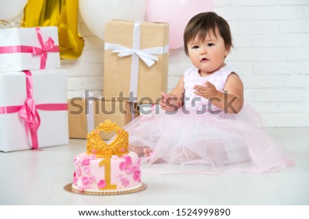 
Birthday of the little Princess. Girl's birthday party with cake, gifts and pink balloons. The first day of birth.
