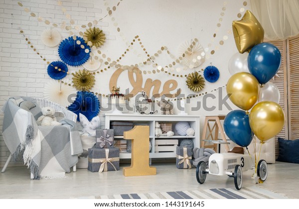 Birthday navy blue and gold decorations with\
gifts, toys, garlands and toy car for yearling little baby party on\
a white background.