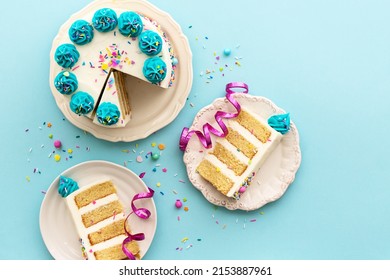Birthday party background with birthday cake and birthday cake slices, overhead view