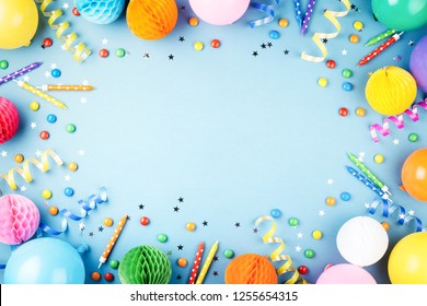 Birthday Party Background On Blue. Top View. Frame Made Of Colorful Serpentine, Balloons, Candles, Candies And Confetti.