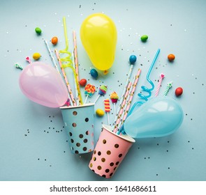 Birthday Party Caps,  Paper Straws, Candy And Baloons On Blue Background