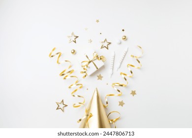 Birthday party celebration with golden decoration top view. Festive holiday background with gift box, carnival hat, candles, confetti, candy and streamers top view. - Powered by Shutterstock