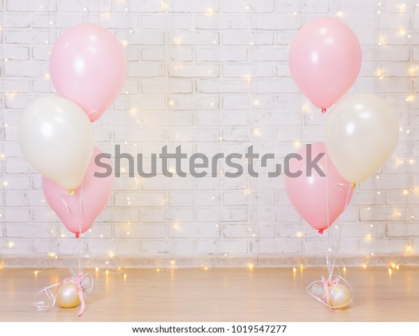 誕生日パーティーのコンセプト レンガ壁の背景に光とピンク風船 の写真素材 今すぐ編集