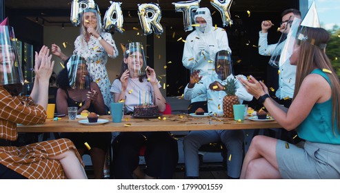Birthday party during COVID-19. Young happy multiethnic friends dancing under confetti with safety measures slow motion.