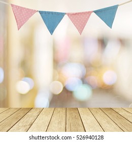 Birthday Party Flag Over Blur Bokeh Background, Banner, Pink And Blue Party Flag Bunting For Happy Birthday Backdrop, Wood Table And Blur Abstract Light Background For Product Display Mockup, Template