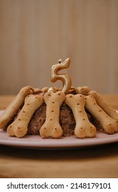 Birthday Party For Pet. Cake Made Of Pate And Cookies In Form Of Bones. The Golden Candle In Pie In Shape Of Number 5 Is Lit So That The Dog Or Cat Has Time To Make A Wish.