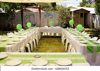 Birthday Party Table Setup With Green Balloons And Decor Outdoors In Yard