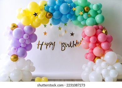 Birthday photo zone. Different decorations a child birthday party at home or in studio.Colorful balloons isolated on white background. Green yellow, blue, purple, pink and white color balloons.