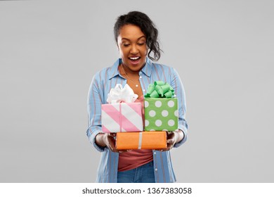 Birthday Present And Surprise Concept - Happy African American Young Woman With Gift Boxes Over Grey Background