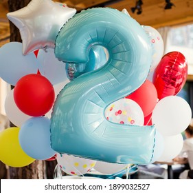 Birthday white, yellow, red and transparent balloons with confetti and and balloon number two. Party with balloons decorations