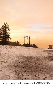 Bischofsheim, Germany - November 9, 2019: Three crosses at the top of the hill at Kreuzberg monastery on a snowy fall afternoon at sunset in Bavaria, Germany.