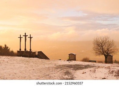 Bischofsheim, Germany - November 9, 2019: Beautiful colorful clouds on a snowy, foggy fall afternoon in the Rhon mountains at the three crosses at the top of the hill above the Kreuzberg monastery in