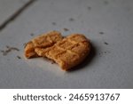 The biscuit crumbs that fell to the floor were surrounded by many ants.