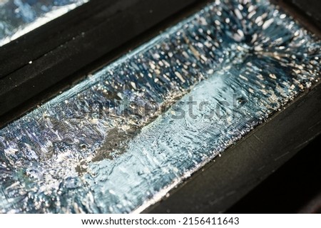 Biscuit of shiny silver cools down in graphite casting form