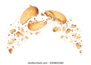 Biscuits broken into two halves with falling crumbs down, isolated on white background