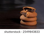 Biscuits filled with chocolate cream. Chocolate cream cookies. brown chocolate biscuits with cream filling on black background.