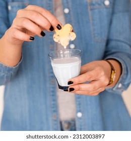 biscuits and milk . Female hand dunking cookie in milk. - Powered by Shutterstock