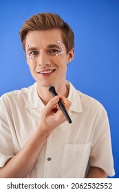 Bisexual Male Beauty Blogger Looking At The Camera And Holding Brush