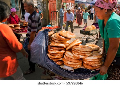 BISHKEK, KYRGYZSTAN - AUG 1: Women Selling Traditional Central Asian Bread On The Popular Osh Market On August 1, 2013. In Kyrgyzstan 34 Perc. Are Under Age Of 15 And 6.2 Perc. Are Over 65.