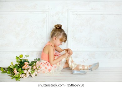 a bit the girl put on as the ballerina and ties a tape on a foot near flowers - Powered by Shutterstock