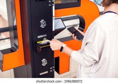Bitcoin ATM. Woman Using Bitcoin Atm To Buy Or To Sell Crypto Coins. Electronic Money Currency