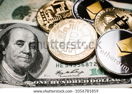 Bitcoin (BTC) and Ethereum (ETH) cryptocurrency (crypto currency) are digital money with decentralized ledger. Gold bitcoin and silver ethereum coins closeup over the one hundred dollar bill