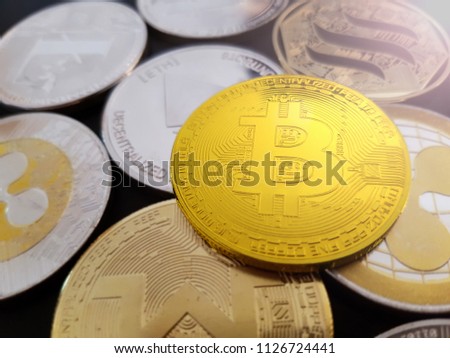 Bitcoin BTC lying on a background of altcoin cryptocurrencies. The cryptocurrency background includes Ripple XRP, Litecoin LTC, Ethereum ETH and others.