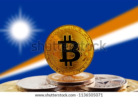 Bitcoin BTC on stack of cryptocurrencies with Marshall Islands flag in background. The cryptocurrency coin is golden and in focus