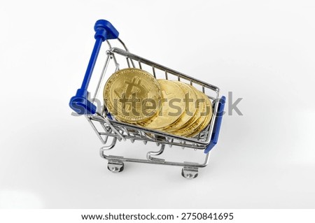 Bitcoin coins inside tiny blue supermarket trolley. Electronic money concept. Crypto currency retail market. Digital asset trade.