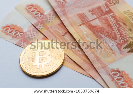 Bitcoin crypto currency coin on Russia Ruble banknotes
