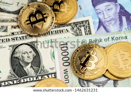 Bitcoin Cryptocurrency coins on South Korea Won and US Dollar currency banknotes close up image. Bitcoin Cryptocurrency concept. Asia BTC Bitcoin Cryptocurrency USA  Dollar USD South Korea Won KRW