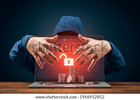 Bitcoin and cryptocurrency cybersecurity concept with hacker behind the unsecured laptop.