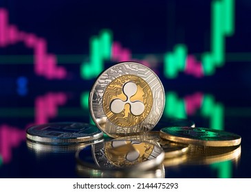 Bitcoin and cryptocurrency investing concept. Cryptocurrency golden coin with gold ripple symbol. Rise and fall charts of alt coins. - Shutterstock ID 2144475293