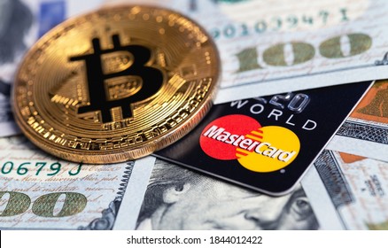bitcoin cryptocurrency and MasterCard cards with money, dollars closeup. MasterCard worldwide is an American multinational financial services corporation. Moscow, Russia - August 16, 2020