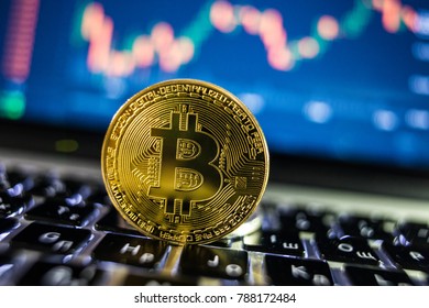 Bitcoin currency with blockchain concept on laptop keyboard with coins and charts and graphs. Crypto investment security and strategy.