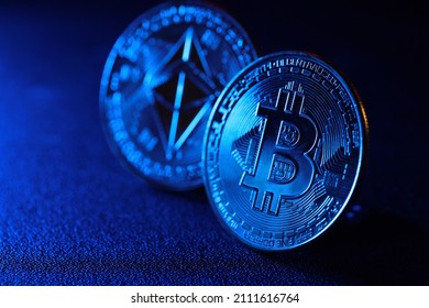 Bitcoin and ethereum coin on a blue back light background. Trading on the cryptocurrency exchange. Selective focus image.