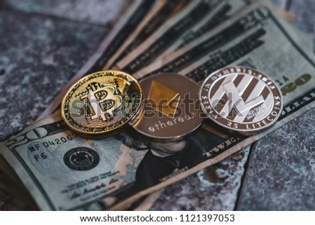 Bitcoin, Ethereum and Litecoin Cryptocurrency Coin Tokens on US Currency
