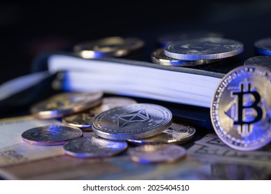 Bitcoin, Ethereum and US Dollar coins on Euro banknotes. Leather Book in the background