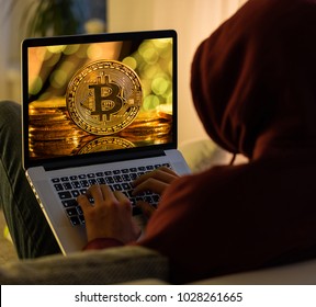 Bitcoin Gold Coin And Anonymous Hacker Sittign With Laptop. Virtual Danger Of Cryptocurrency.